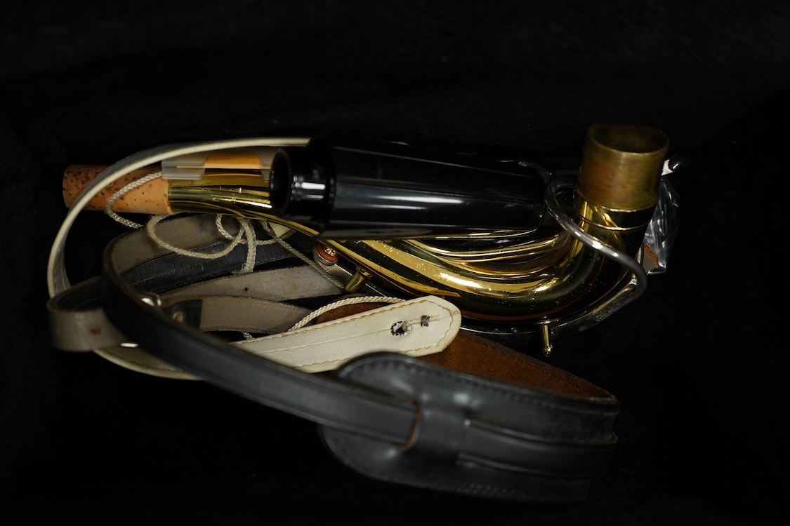 A cased Buescher Aristocrat tenor saxophone and stand